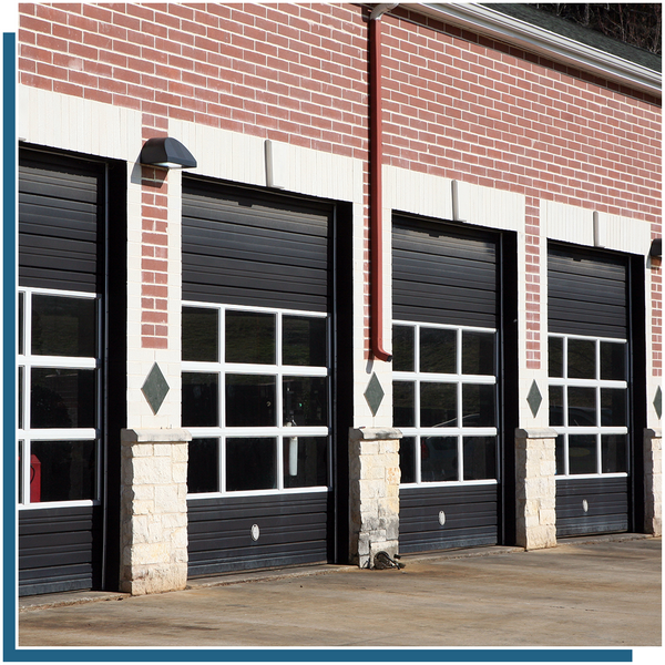 row of black garage doors in brick building with window sections