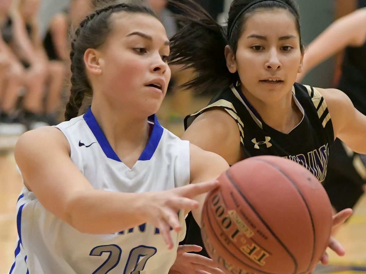 photo of 2 high school aged girls playing basketball