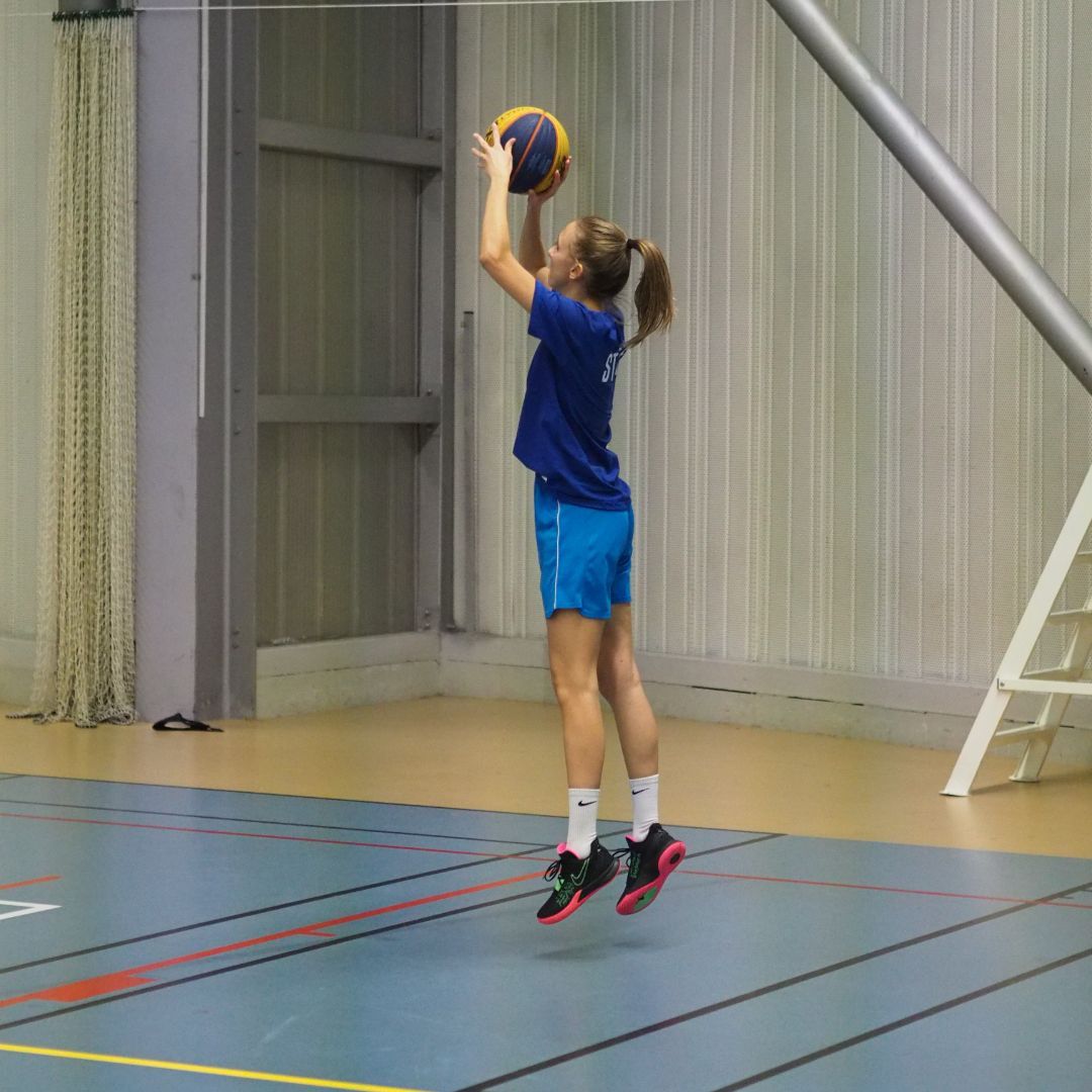 A college female athlete shooting a basketball