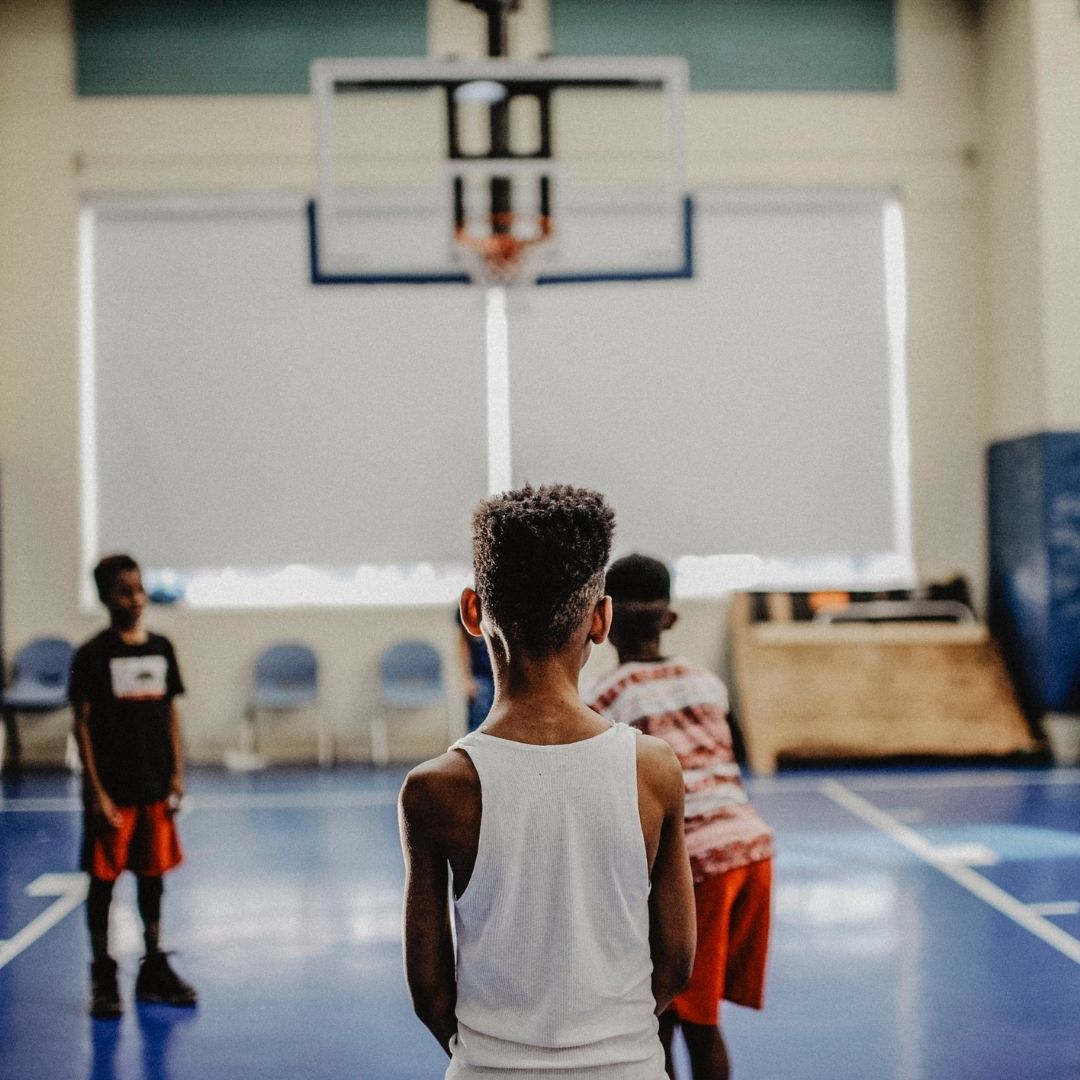 young kids playing on a basketball court