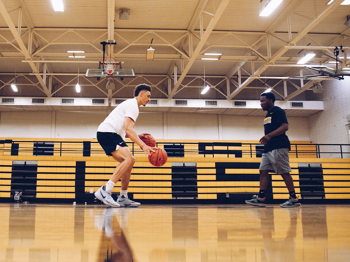 two young men practicing basketball drills