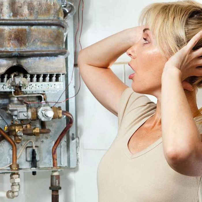 woman covering her ears next to water heater