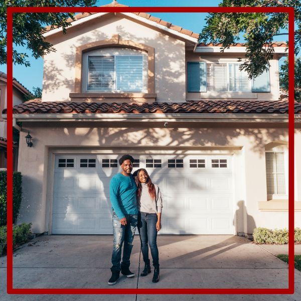 Homeowners in front of their house