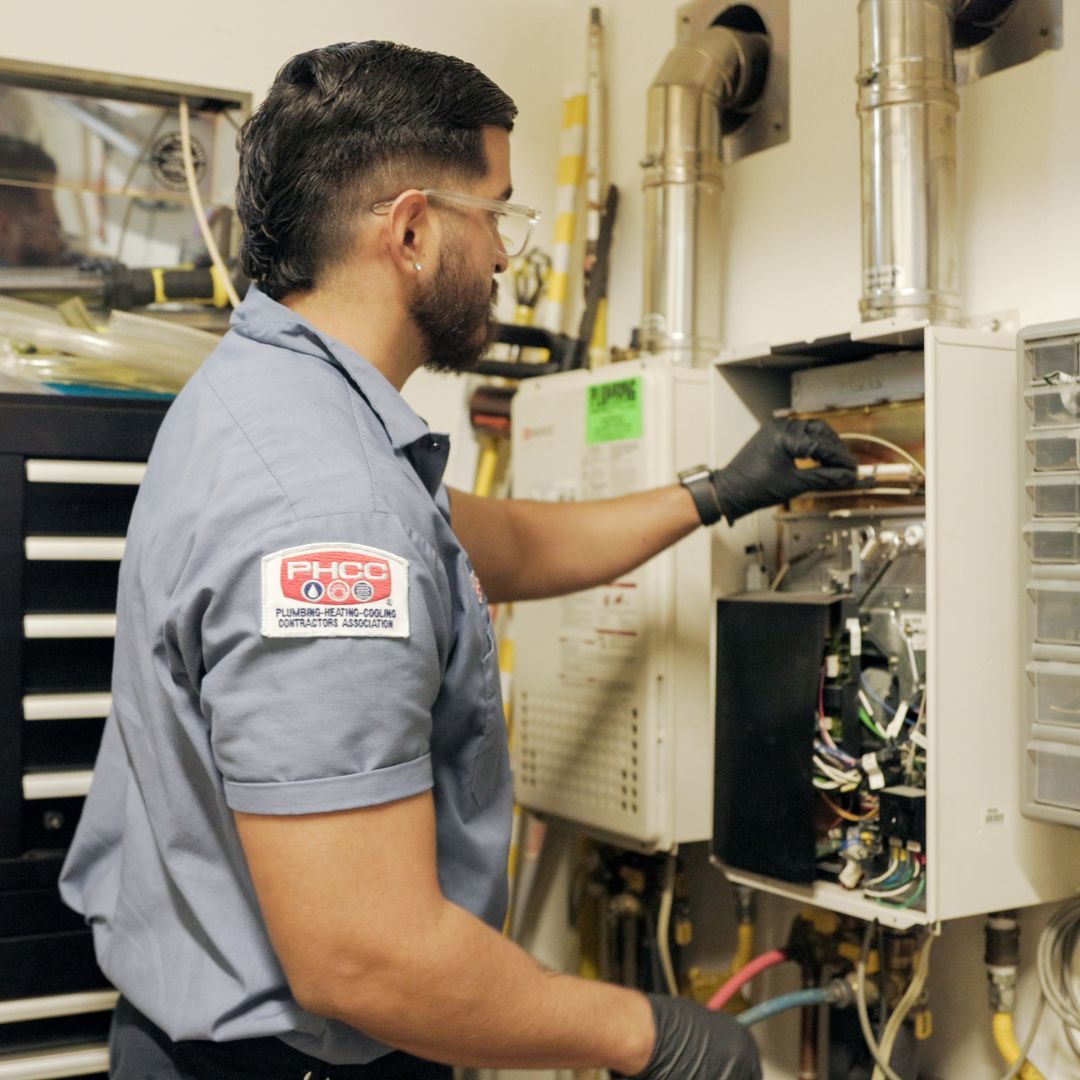 Plumbing Plus conducting maintenance on water heater