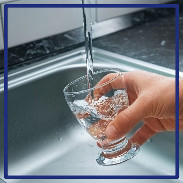 Clean water from a faucet pouring into a cup
