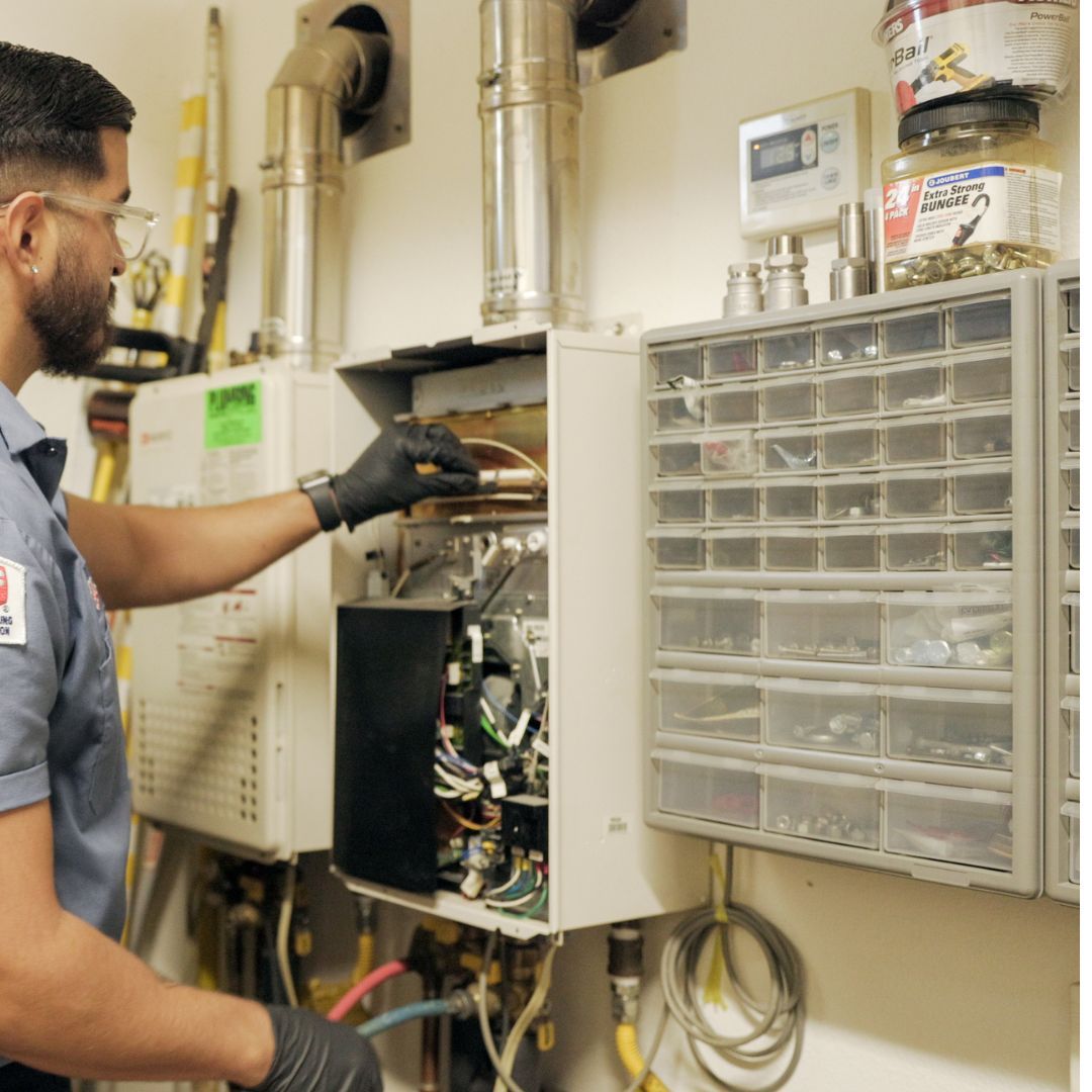 Plumbing Plus tech checking rod in water heater