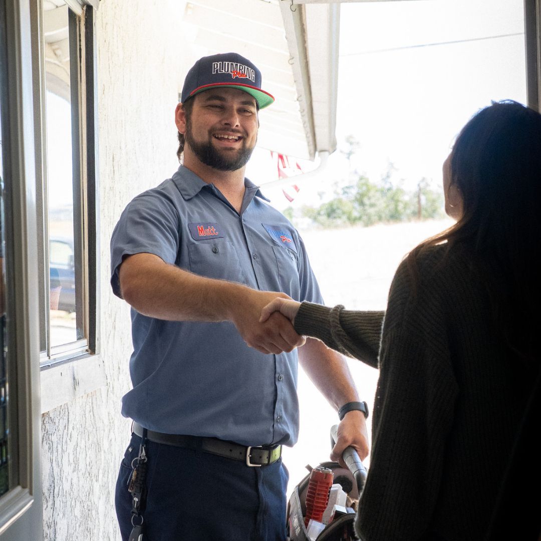 Plumbing Plus tech shaking hands with homeowner