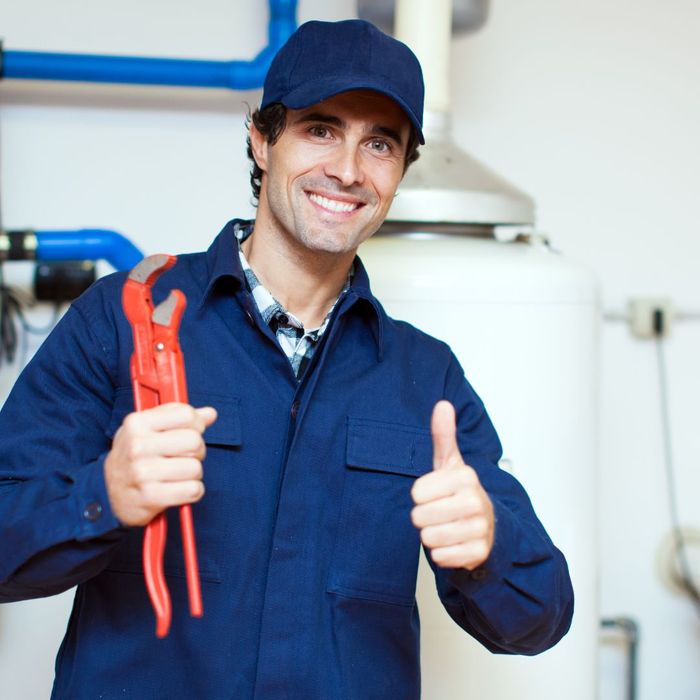 plumber holding orange wrench holding thumbs up smiling