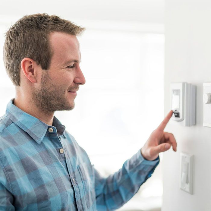 Man changing temperature on thermostat