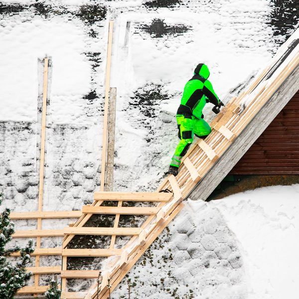 A roofer working on repairs in the snow