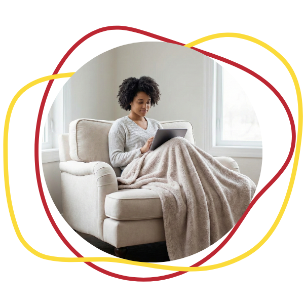 Person looking at their laptop in a comfy chair 