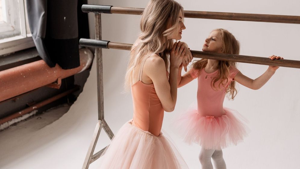 mother and daughter in dance outfits in ballet studio looking at each other mother and daughter in dance outfits in ballet studio looking at each other