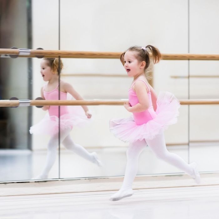 smiling little girl in tutu and leotard running in dance studio smiling little girl in tutu and leotard running in dance studio
