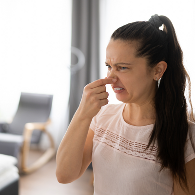 woman pinching nose from musty odors