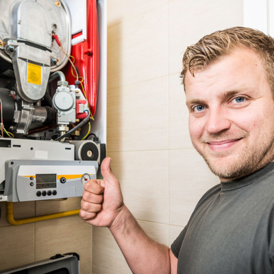 HVAC technician giving a thumbs up near a furnace