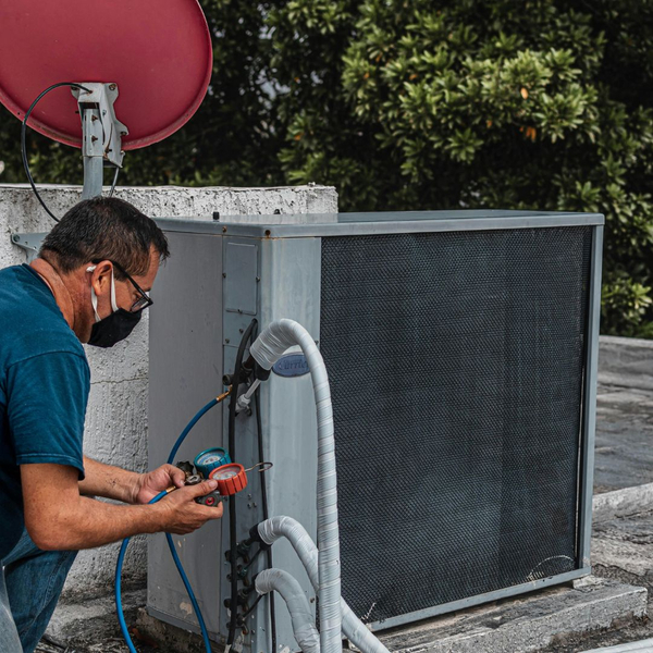 inspecting AC condenser on rooftop
