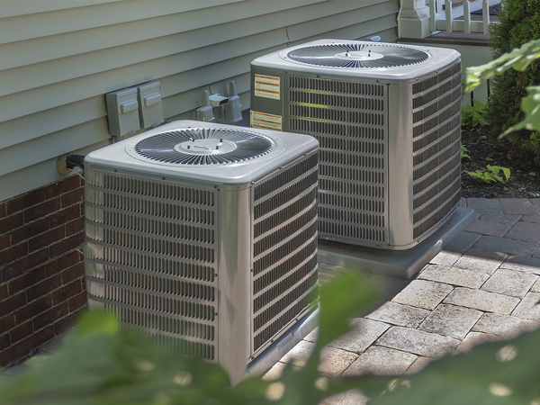 Two air conditioning units sitting outside. Two air conditioning units sitting outside.