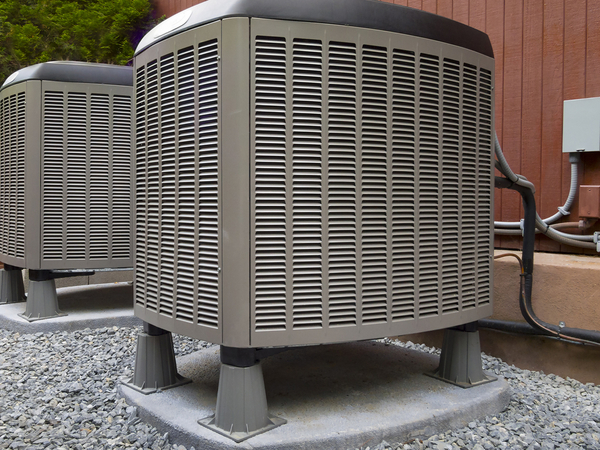 Two air conditioning units sitting outside.