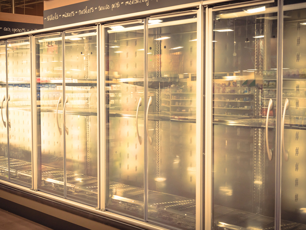 Empty commercial fridges at grocery store.