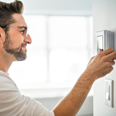 Man adjusting a thermostat
