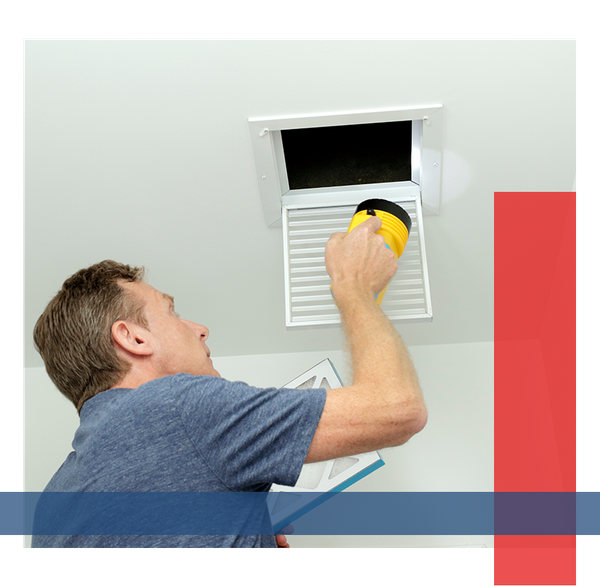 Man using a flashlight to look inside of his vents.