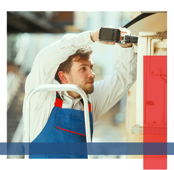 Man using a drill and working on an HVAC unit.