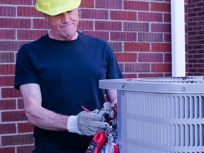 HVAC Technician diagnoses outdoor air conditioning condenser with tools and gauges. HVAC Technician diagnoses outdoor air conditioning condenser with tools and gauges.