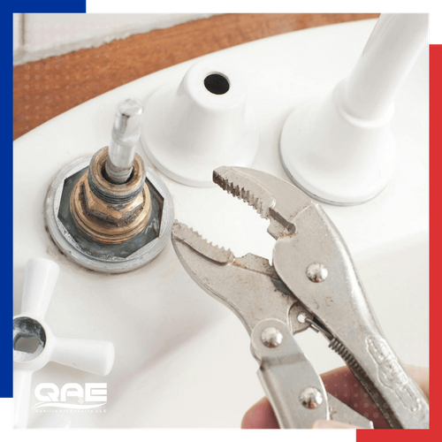plumber using a wrench on a sink