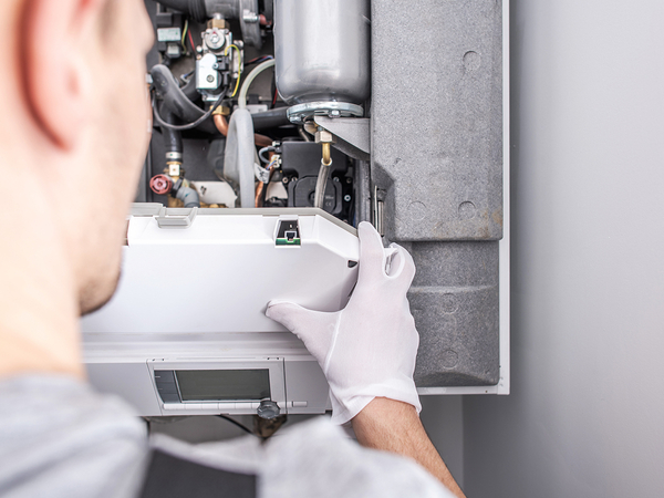 Close Up Of Service Worker Fixing Central Heating Furnace System.