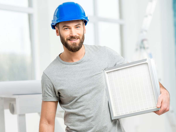 Technician holding filter for smaller unit