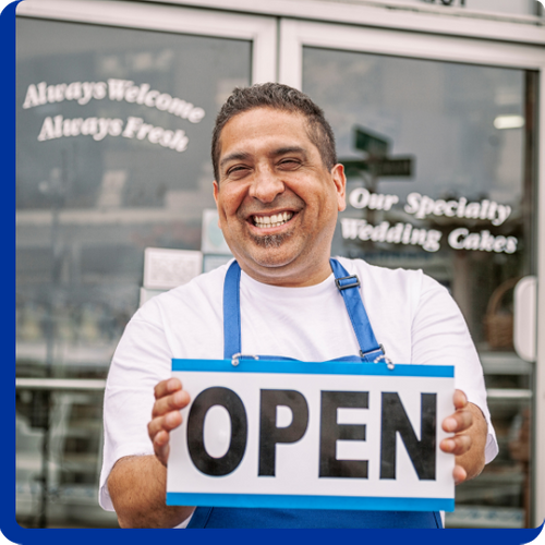 Business owner holding up an open sign