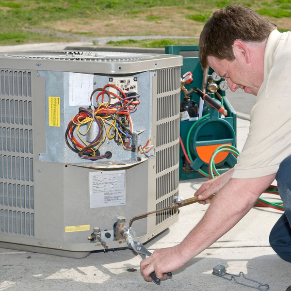 A man inspecting an ac unit