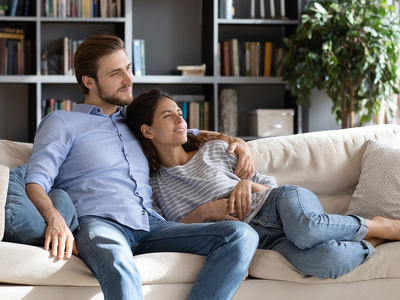 Happy young couple relaxing on cozy sofa at home.