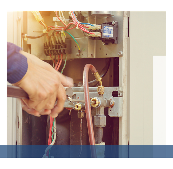 HVAC technician making adjustments to an HVAC unit.