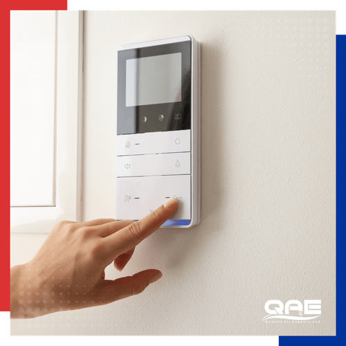 person adjusting their thermostat