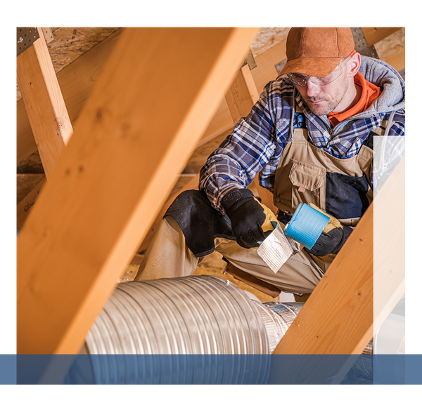 HVAC technician working on vents in an attic.