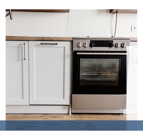 Image of an oven next to white cabinets.