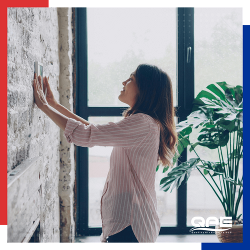 woman adjusting a thermostat