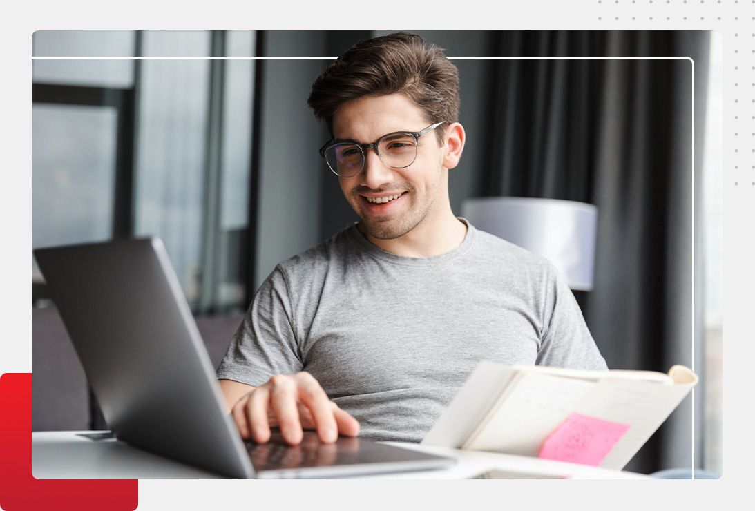man smiling at desk during online class