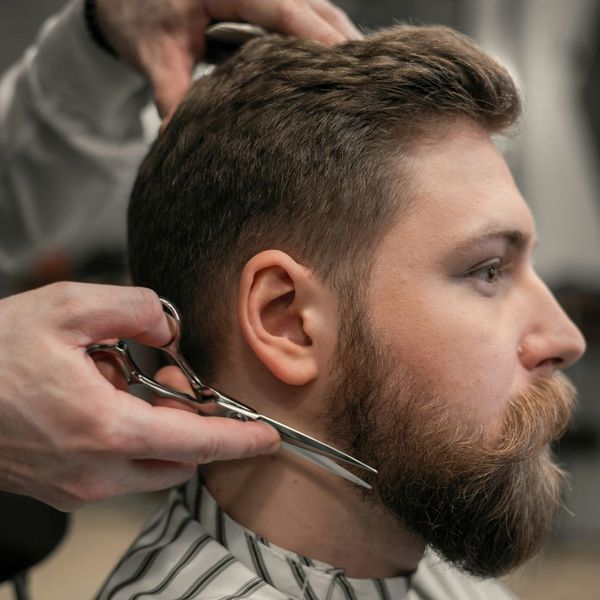 man getting beard trimmed at barbershop man getting beard trimmed at barbershop