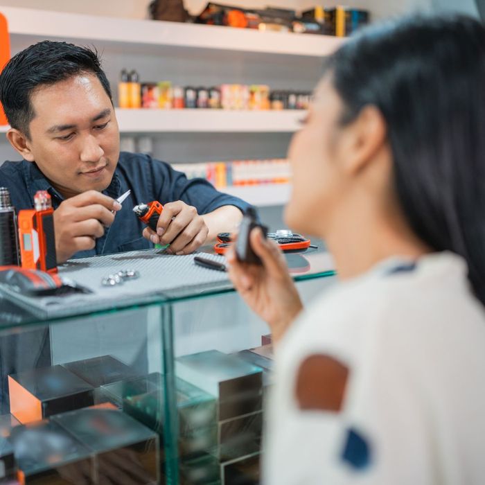 Vape shop worker setting up a device