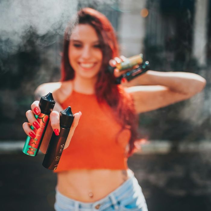 Woman holding up multiple vaping products