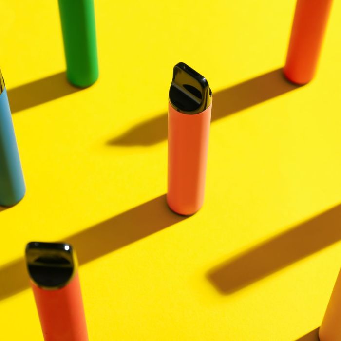 disposable vape pens on yellow background