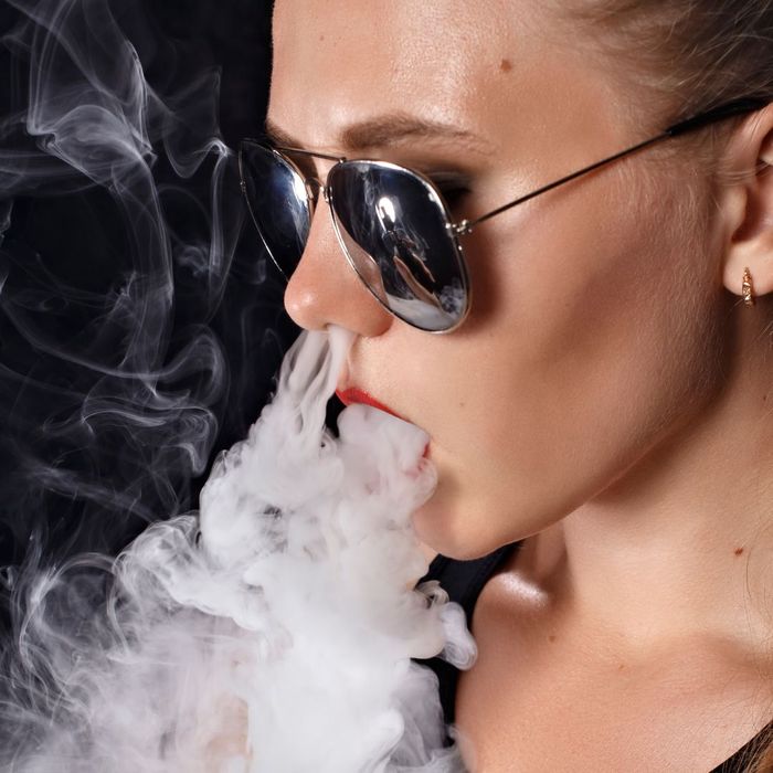 woman exhaling vape smoke