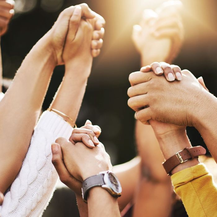 Group of people grabbing hands and raising them up