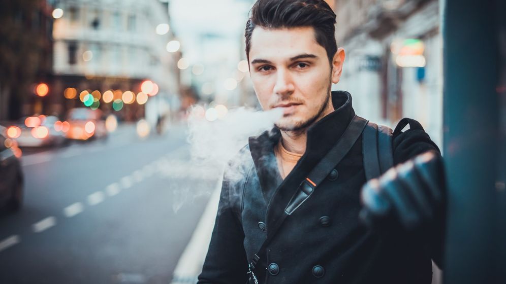 man exhaling vape smoke