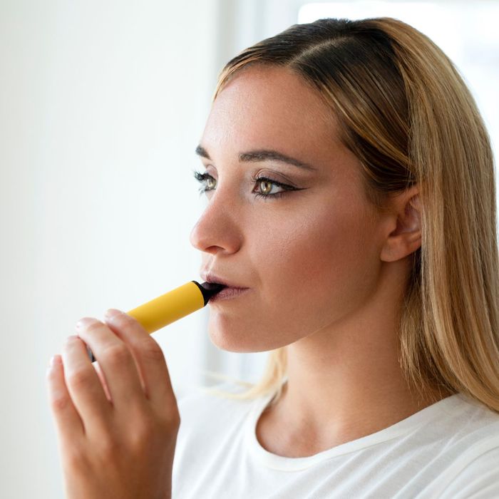 woman with disposable vape pen