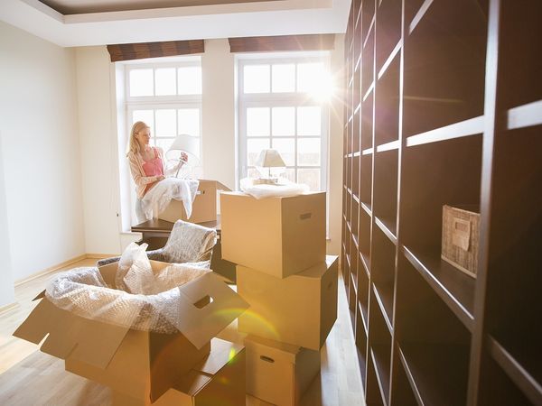 photo of woman packing moving boxes