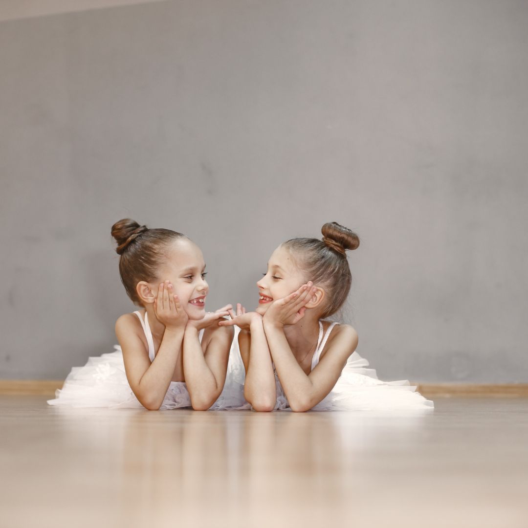 two girls in ballet outfits looking at each other