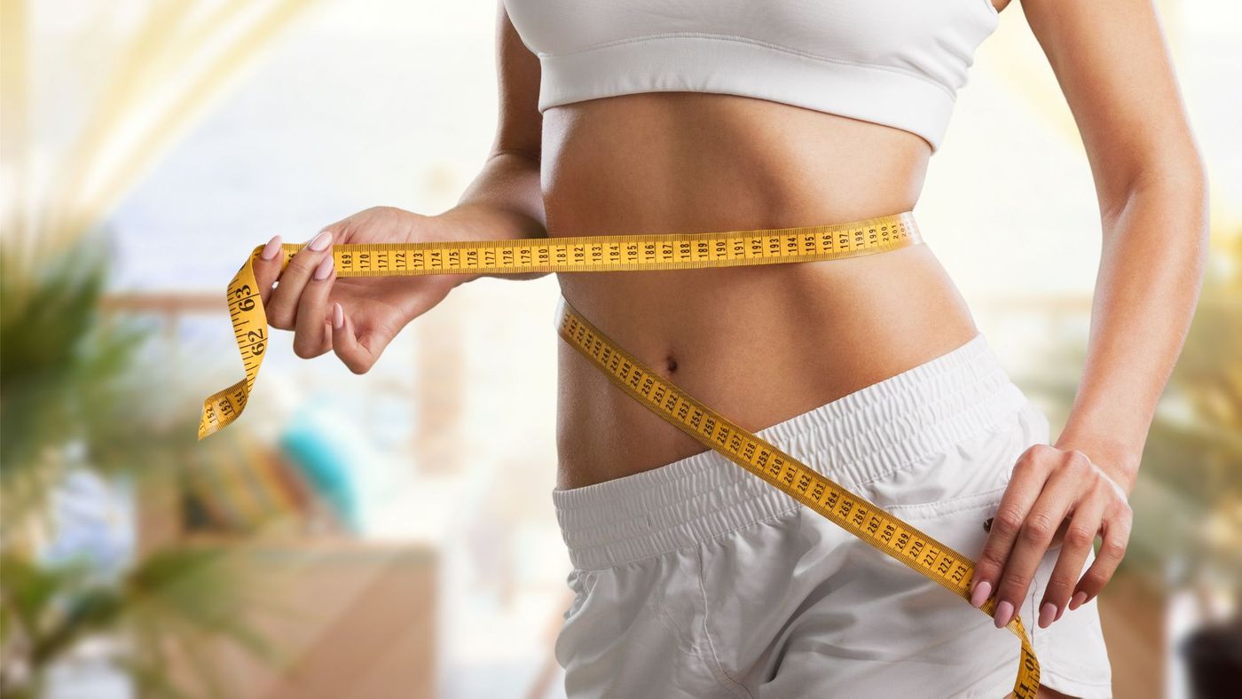 Women measuring her stomach with a tape measurer